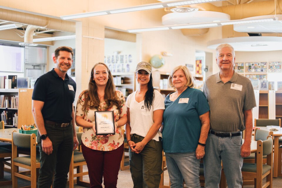 Ernest Stapleton Elementary School Librarian, Laraine Hostetler is presented with the Laura Rasmussen Love of Reading Award by Dion’s CEO Mark Herman, along with Michelle Montoya of the Albuquerque Isotopes and members of the Rasmussen Family including Laura’s parents Janel and John Rasmussen